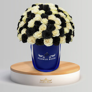 white and black roses in a royal blue box