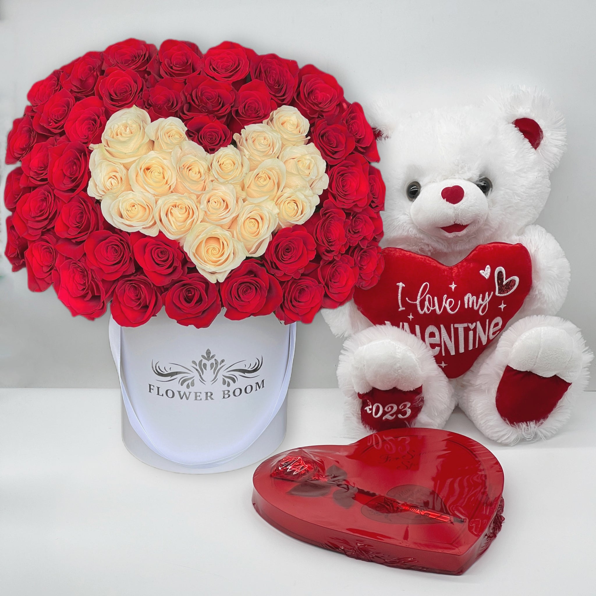 white heart rose box with white and red roses, white plush toy and red box of assorted chocolates